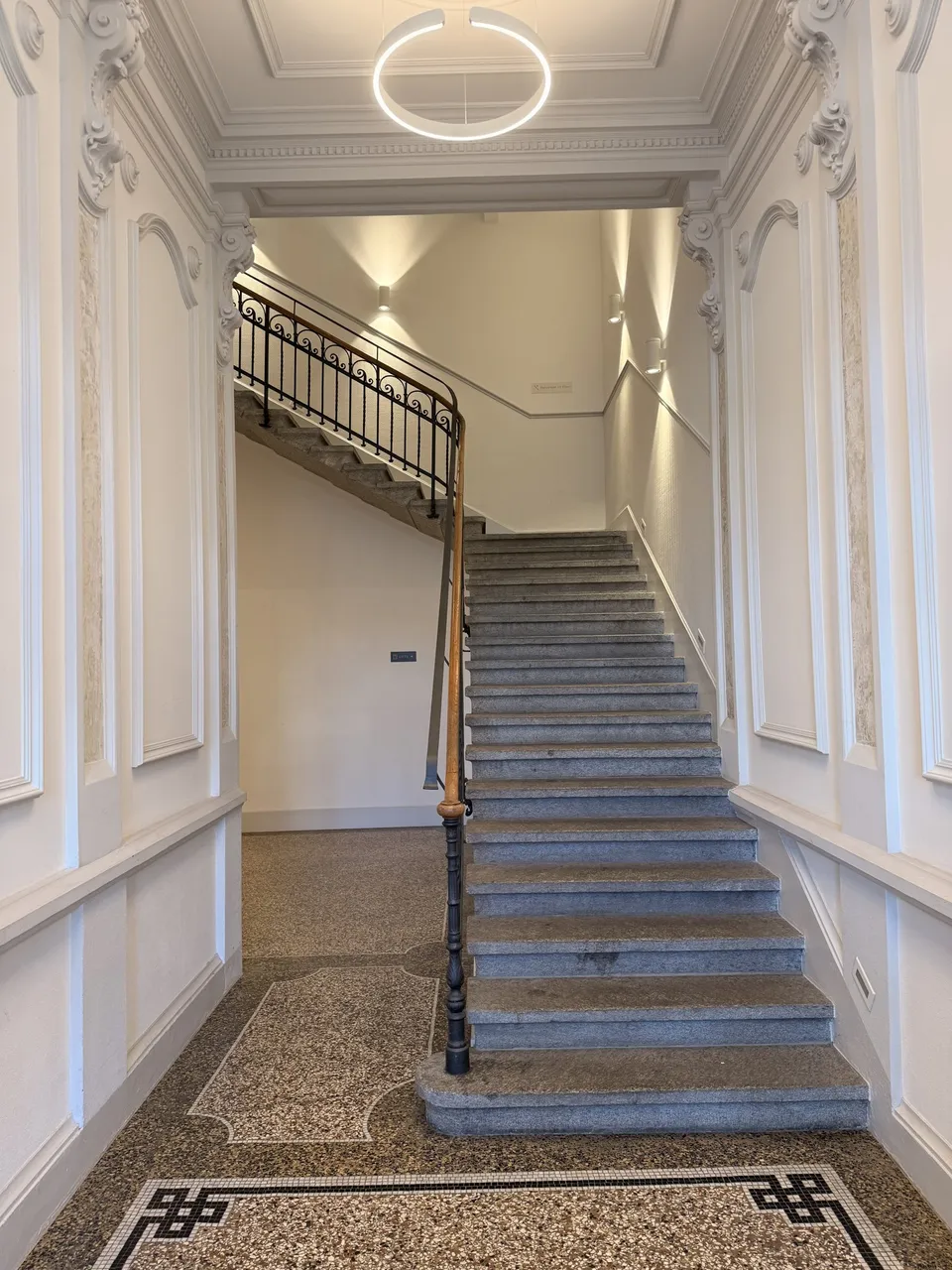 Eingangshalle mit Treppe und Mosaikboden im Haus Bahnhofplatz 1