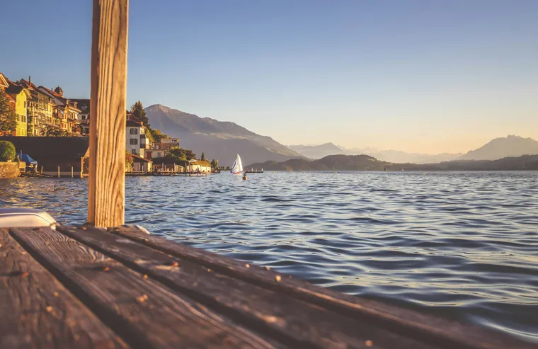 Holzsteg am Zugersee mit Blick auf Häuser und Berge